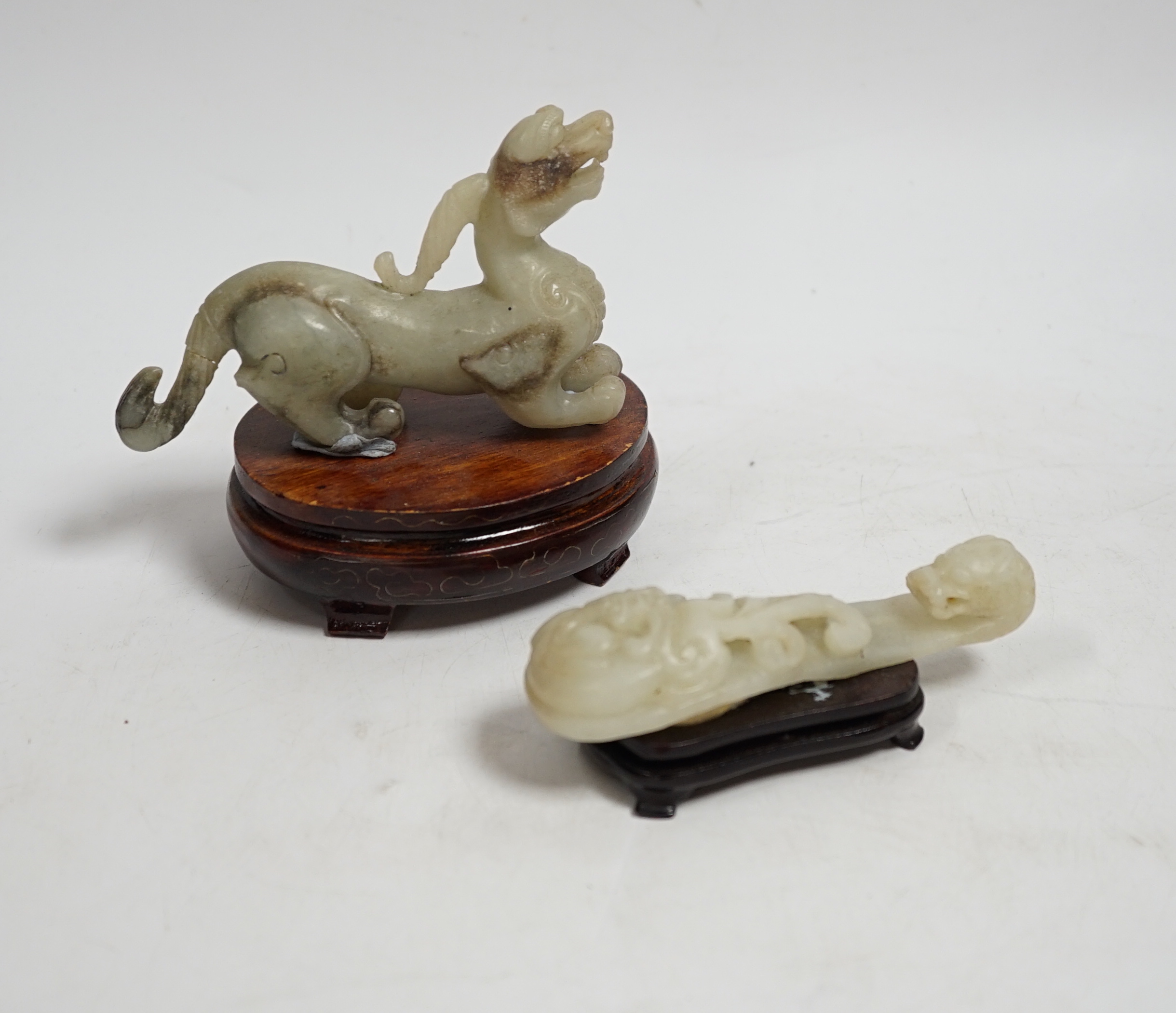 A Chinese pale celadon and grey jade mythical beast on stand, and a pale celadon jade belt hook, mythical beast 11cm wide